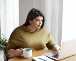 Junge Übergewichtige Frau am Laptop