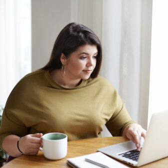 Junge Übergewichtige Frau am Laptop