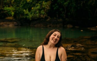 Eine junge positive curvy Frau in einem Badesee.