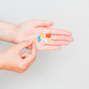 Eine Handfläche auf der bunte Tabletten liegen.