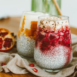 Zwei Gläser mit Chia Pudding und Fruchtmuß befüllt.