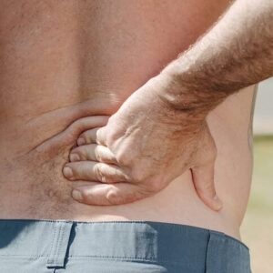 Ein Mann hält sich den schmerzenden Rücken.