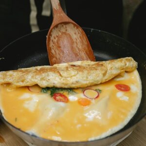 Ein frisches Gemüseomelette wird gewendet.