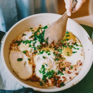 Eine Pfanne mit Spiegeleiern und Kräutern.