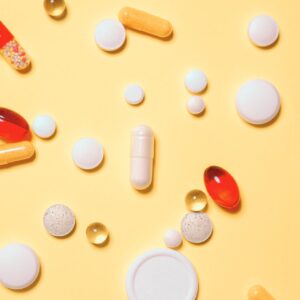 Auf einem gelber Untergrund liegen Tabletten.