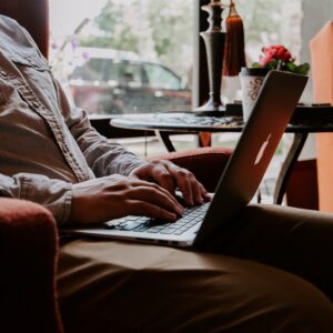 Laptop auf dem Schoß von einem Mann