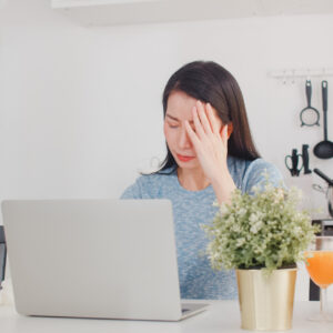 Frau sitzt am Tisch und ist angeschlagen