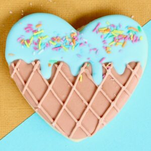 Herz aus Kuchen mit Zuckerguss auf einem bunten Hintergrund