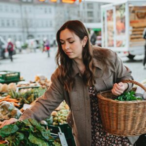 Frau kauf Gemüse auf einem Markt ein