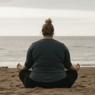 PLus size Frau meditiert am Strand.