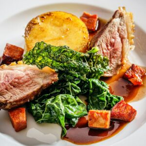 Fleischgericht mit Kartoffeln und Gemüse.