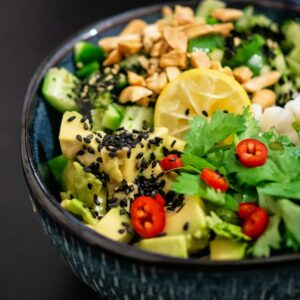 Eine bunte asiatische Bowl mit Gemüse, Koriander und Chili.
