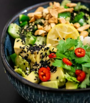 Eine bunte asiatische Bowl mit Gemüse, Koriander und Chili.