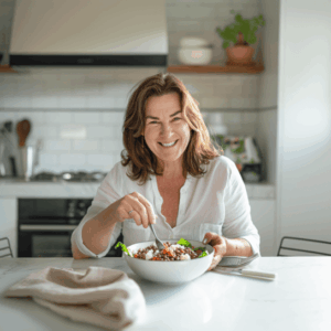 Eine Frau isst glücklich einen Salat in ihrer Küche.