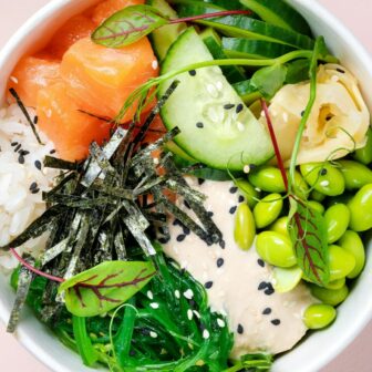 Eine Bowl mit Reis, Gemüse und Lachs.