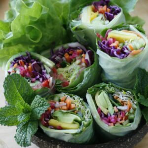 Eine Schale mit Sommerrollen gefüllt mit Gemüse.