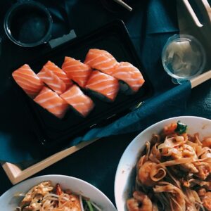 Ein Tisch mit Sushi Rollen sowie Nudeln Gerichte