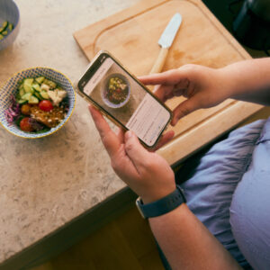 Frau nimmt Mahlzeit für Ernährungstagebuch auf