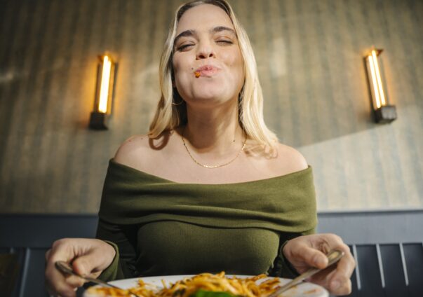 Frau genießt Pasta Gericht.