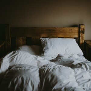 Ein bezogenes Holzbett.