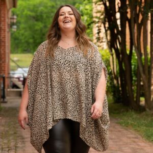 Eine lachende Plus size Frau geht fröhlichen einen Weg herunter.