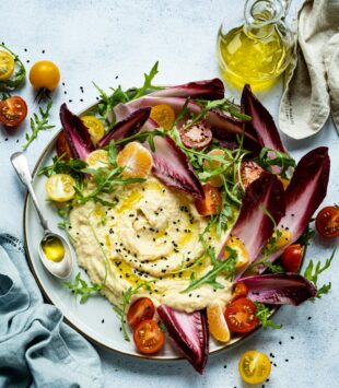 Ein Teller mit Hummus und Chicoree.