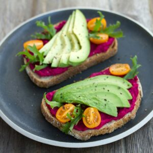 EIn gesundes Brot mit Rote Beete Hummus und Avocado.