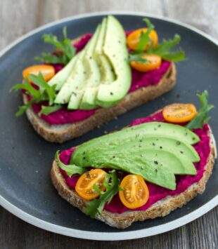 EIn gesundes Brot mit Rote Beete Hummus und Avocado.