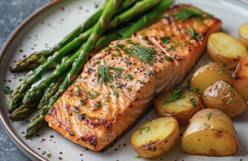 Gegrillter Lachs auf einem Teller mit Spargel und Ofenkartoffeln