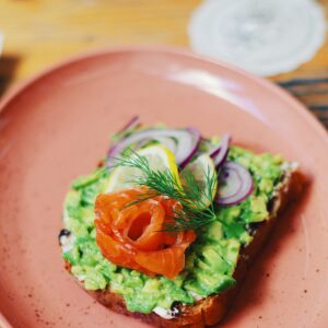 Ein eine Scheibe Brot mit Guacamole, Lachs und Zwiebeln.