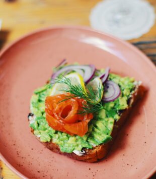 Ein eine Scheibe Brot mit Guacamole, Lachs und Zwiebeln.