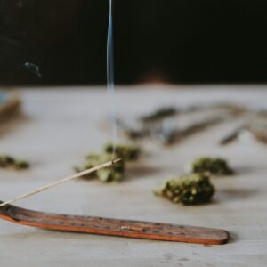 Ein angezündetes Räucherstäbchen auf einem Holztisch