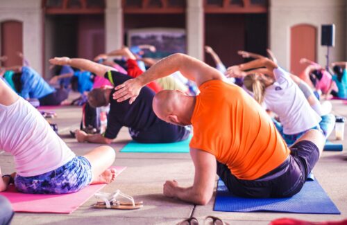 Eine Gruppe von Männern und Frauen macht gemeinsam Yoga und isometrische Übungen.