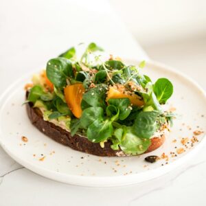 Ein frisches Brot belegt mit Avocado und Feldsalat.