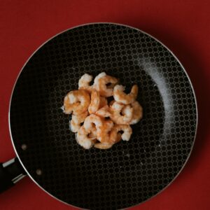 Garnelen in einer Pfanne auf einem roten Tisch