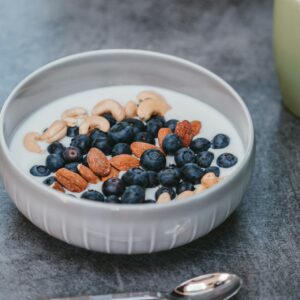 Eine gesunde Joghurt Bowl mit Blaubeeren, Mandeln und Cashews.