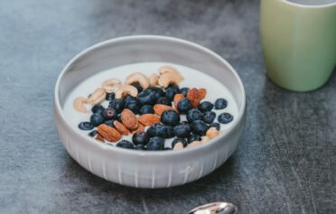 Eine gesunde Joghurt Bowl mit Blaubeeren, Mandeln und Cashews.