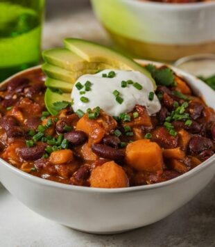 Eine Schüüsel mit Chili con Carne getoppt mit Sour Cream und Avocado.