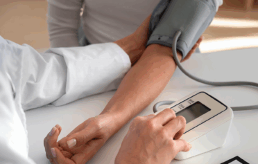 Ein Bildausschnitt eines Arms, an dem gerade der Blutdruck gemessen wird.