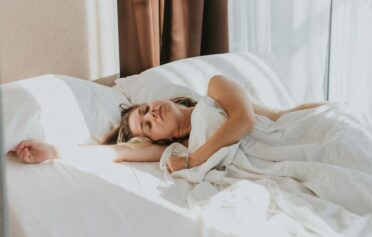 Eine Frau liegt auf der Seite schlafend im Bett.