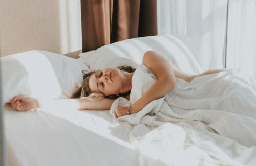 Eine Frau liegt auf der Seite schlafend im Bett.