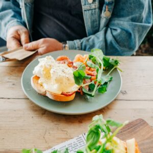 Ein Brot mit Lachs und Spiegelei mit Salatbeilage.