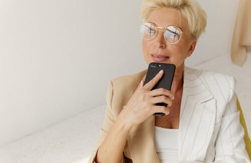 Eine Frau in den Wechseljahren sitzt mit ihrem Handy