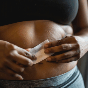 Eine Frau klebt sich ein Abnehmpflaster auf ihrem Bauch auf.