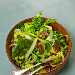 Eine Schüssel mit grünem Löwenzahnsalat mit vielen Bitterstoffen.