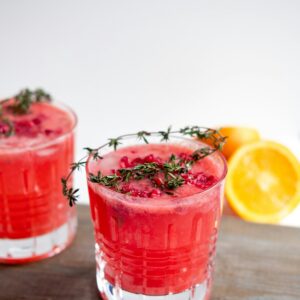 Ein roter frischer Saft mit einem Rosamarin Zweig.