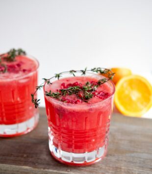 Ein roter frischer Saft mit einem Rosamarin Zweig.