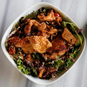 Ein grüner Chicoree Salat mit gebratenem Hähnchen.