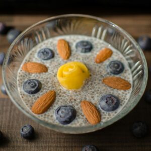 Eine Schale mit Chiapudding, Nüssen und Blaubeeren.