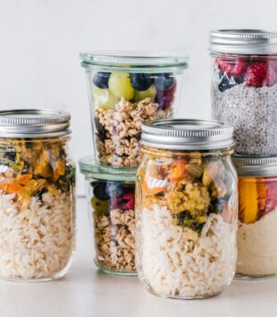 Verschiedene Gläser mit Lebensmitteln als Meal Prep vorbereitet.
